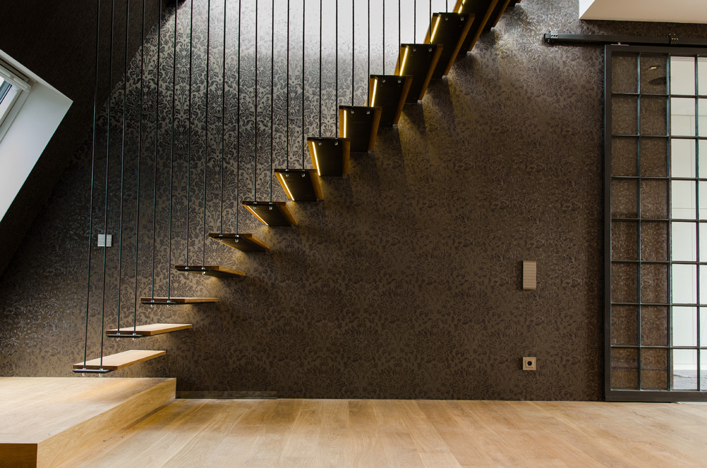 Aménagement d'un grand escalier flottant industriel avec des marches en bois.