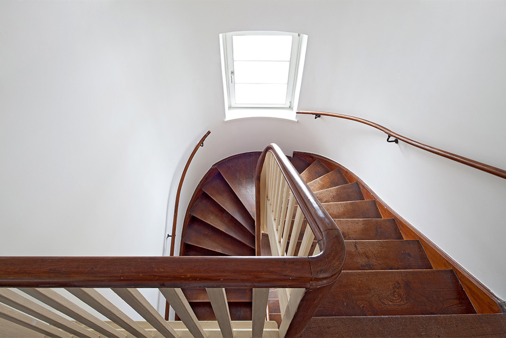 Пример оригинального дизайна: изогнутая деревянная лестница среднего размера в классическом стиле с деревянными ступенями