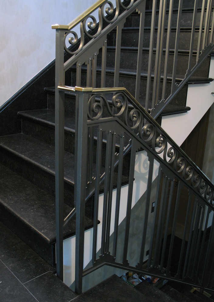 Cette image montre un très grand escalier carrelé droit traditionnel avec des contremarches carrelées et un garde-corps en métal.