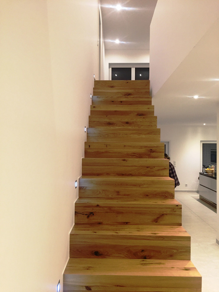 Réalisation d'un grand escalier droit design avec des marches en bois et des contremarches en bois.