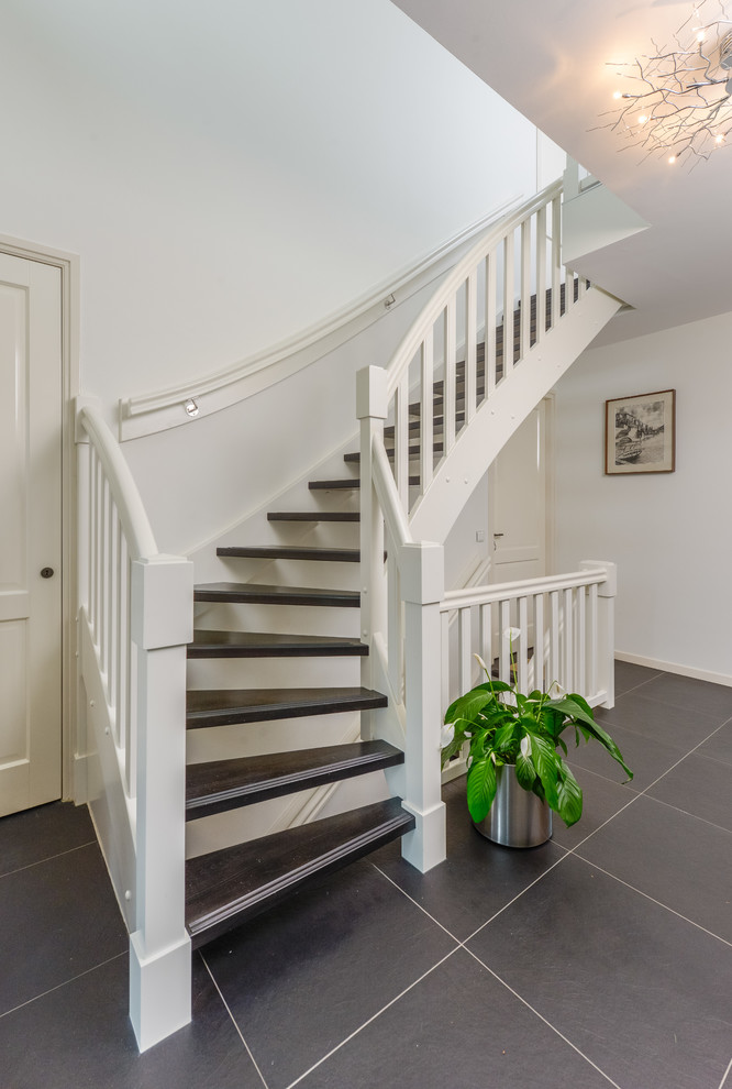 Idée de décoration pour un escalier sans contremarche courbe tradition de taille moyenne avec des marches en bois.