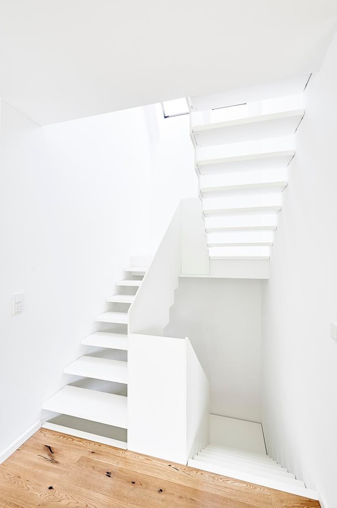 Design ideas for a small contemporary wood u-shaped staircase in Dortmund with wood risers.