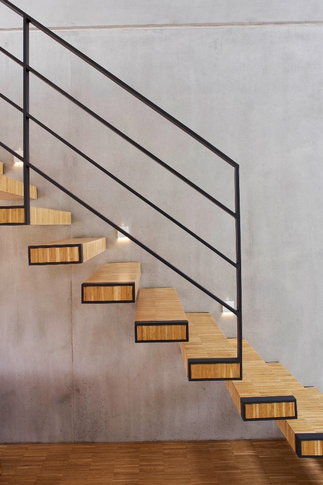 Diseño de escalera recta moderna de tamaño medio sin contrahuella con escalones de madera y barandilla de metal