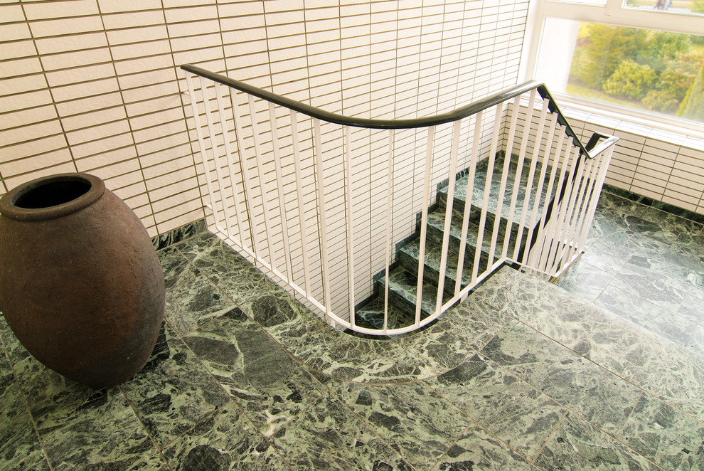 На фото: п-образная лестница в стиле ретро с ступенями из плитки и подступенками из плитки с