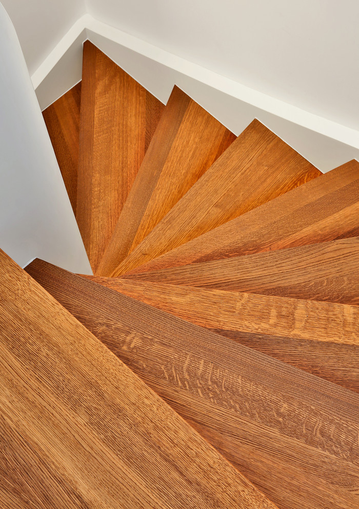 Diseño de escalera curva contemporánea pequeña con escalones de madera, contrahuellas de madera y barandilla de madera