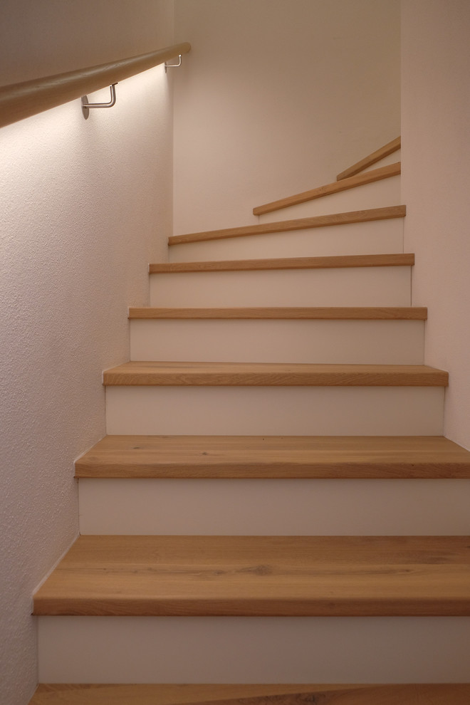 Ejemplo de escalera en U nórdica de tamaño medio con escalones de madera y barandilla de madera