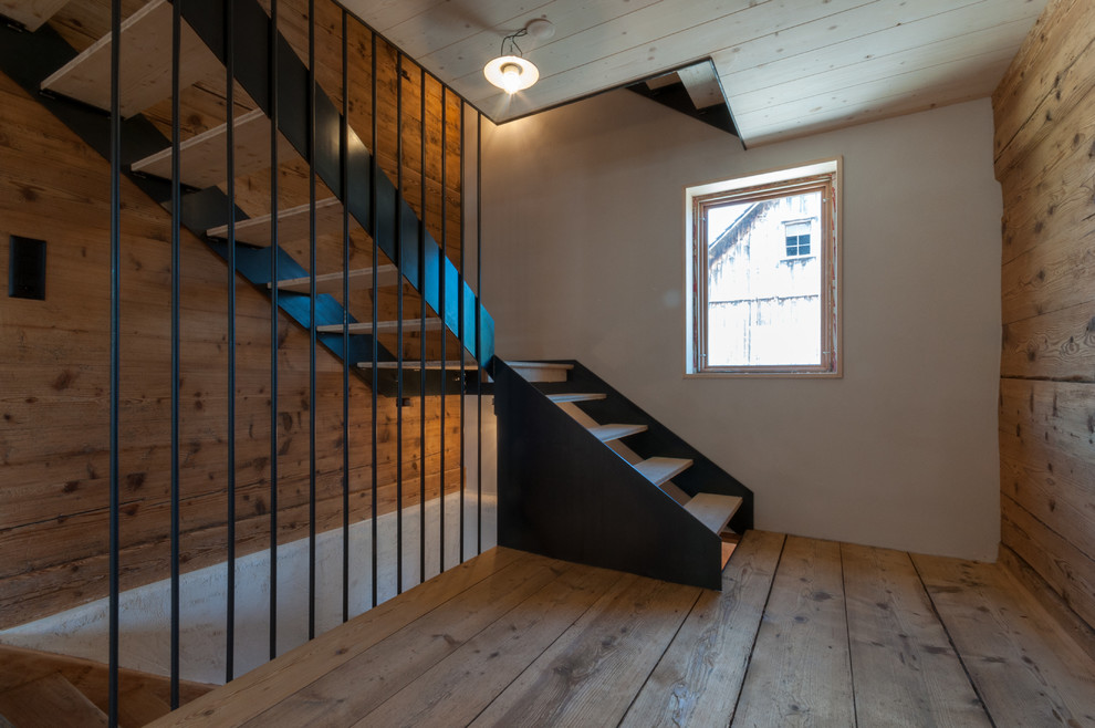 Foto de escalera en L campestre con escalones de madera y contrahuellas de metal