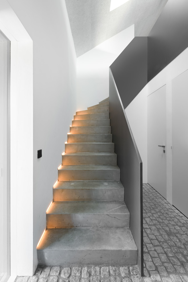 Imagen de escalera en L minimalista de tamaño medio con escalones de hormigón y contrahuellas de hormigón