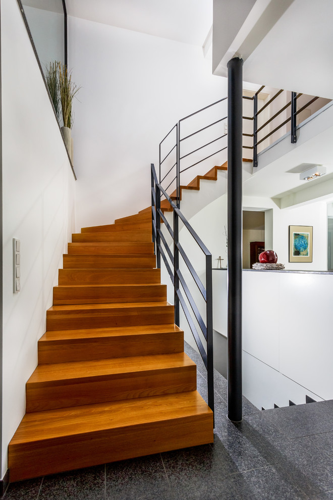 Foto de escalera curva contemporánea de tamaño medio con escalones de madera y contrahuellas de madera