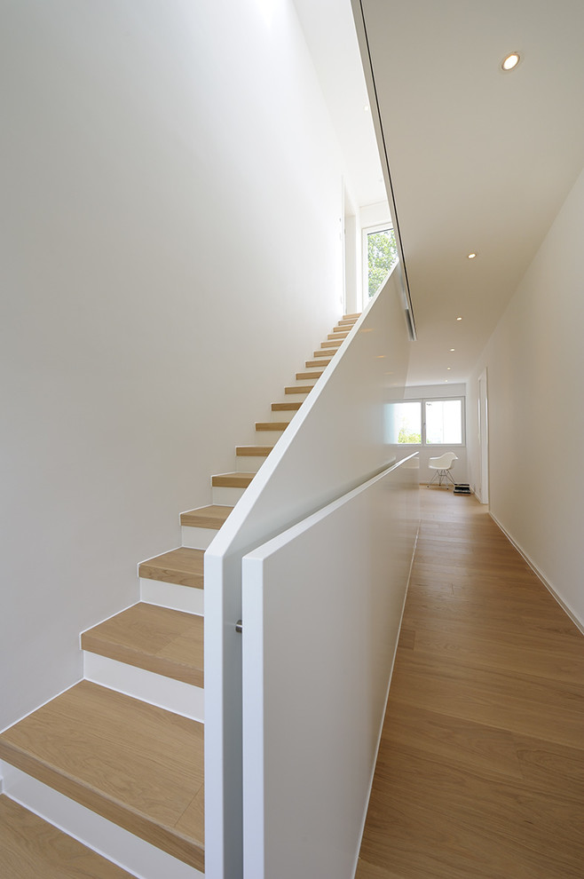 Пример оригинального дизайна: большая прямая лестница в современном стиле с деревянными ступенями