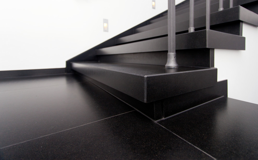 Cette photo montre un escalier droit tendance en marbre de taille moyenne avec des contremarches en marbre et un garde-corps en métal.