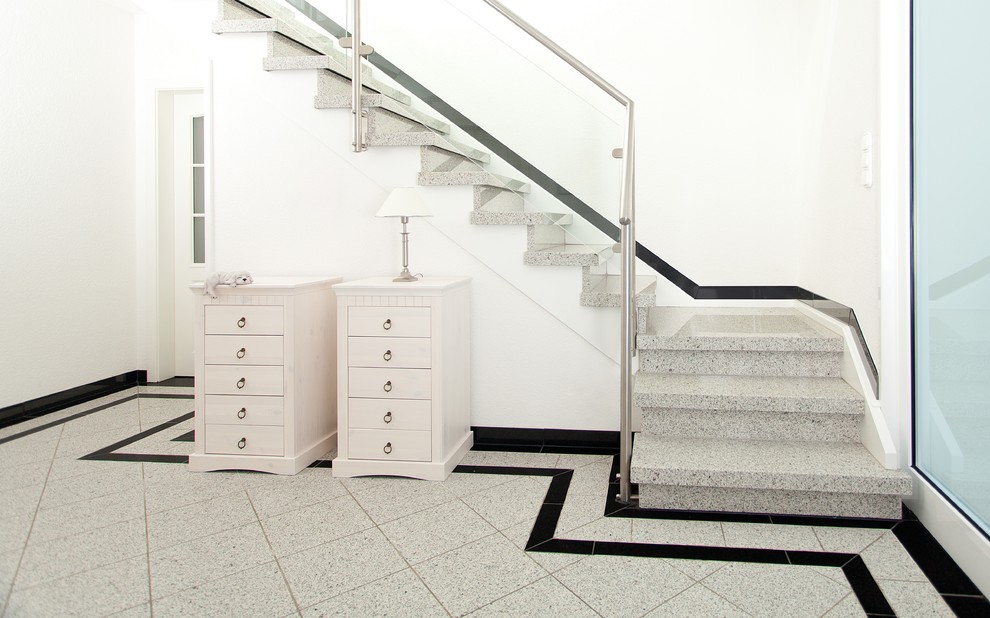 Ejemplo de escalera en L tradicional con escalones de mármol y contrahuellas de mármol