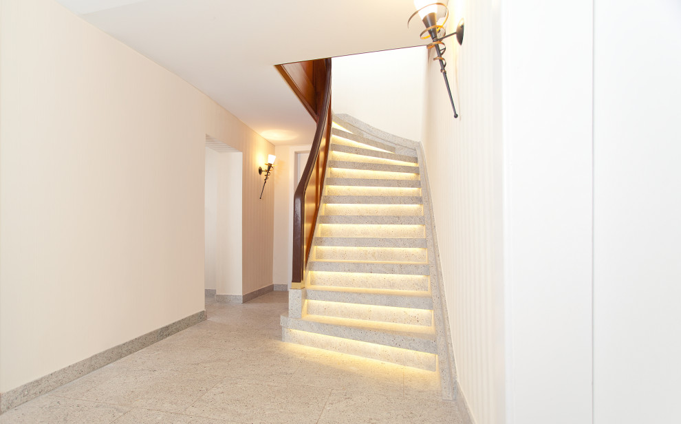 Small farmhouse marble curved wood railing staircase photo in Dortmund with marble risers