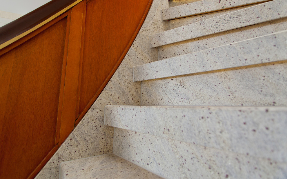 Inspiration för små lantliga svängda trappor i marmor, med sättsteg i marmor och räcke i trä