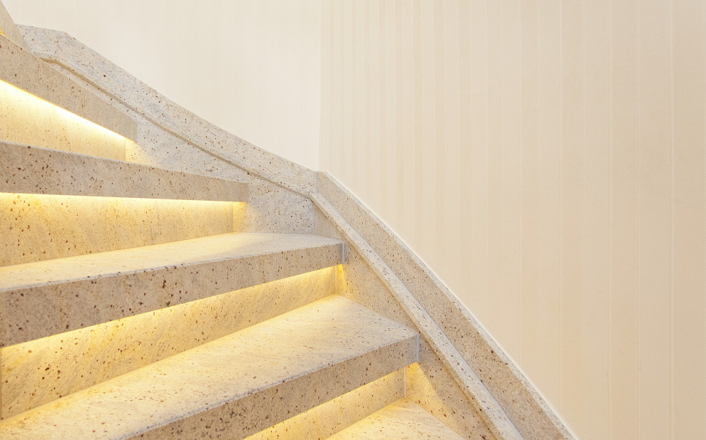 Exempel på en liten lantlig svängd trappa i marmor, med sättsteg i marmor och räcke i trä