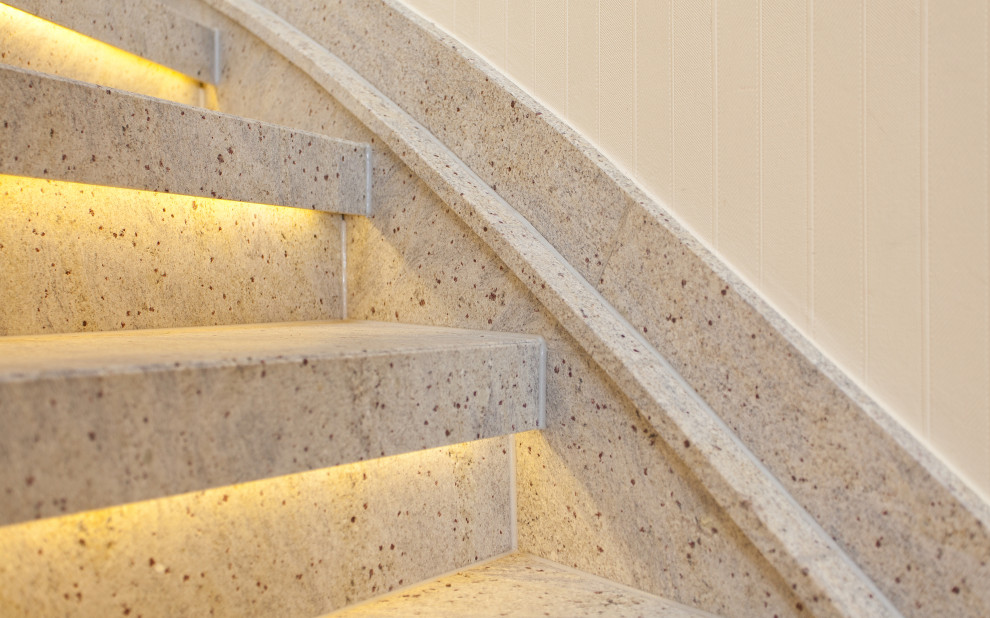 Diseño de escalera curva de estilo de casa de campo pequeña con escalones de mármol, contrahuellas de mármol y barandilla de madera