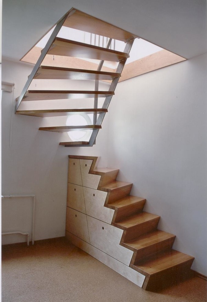 На фото: маленькая изогнутая деревянная лестница в современном стиле с деревянными ступенями для на участке и в саду с