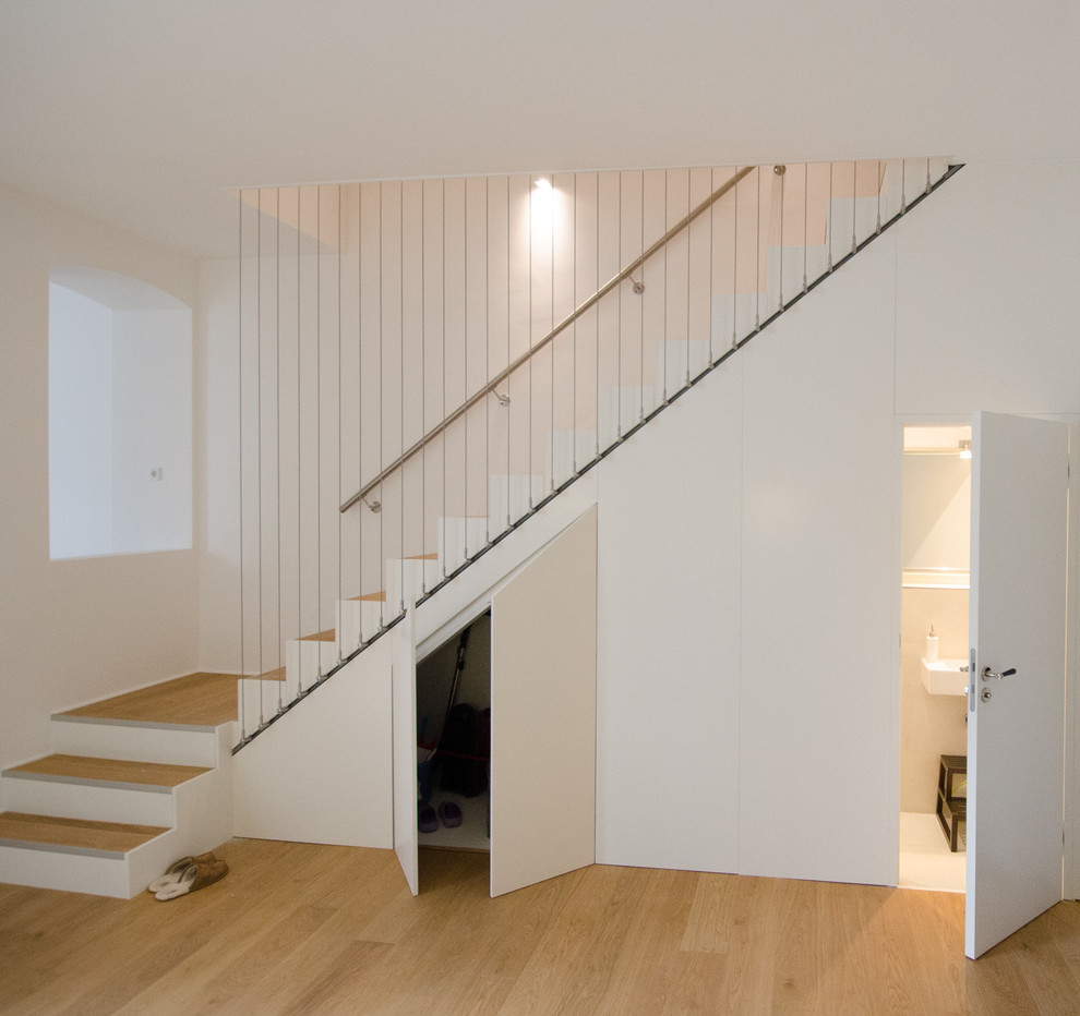 Aménagement d'un escalier contemporain en L avec des marches en bois et des contremarches en bois.