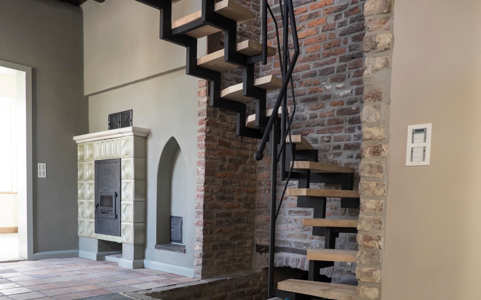 Small rustic wood curved staircase in Dusseldorf with open risers.