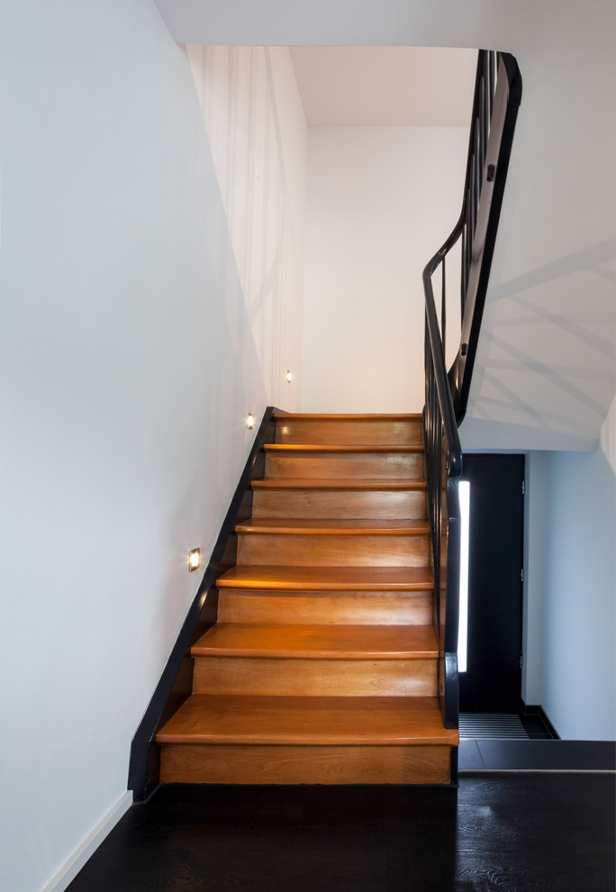 Imagen de escalera en U contemporánea de tamaño medio con escalones de madera y contrahuellas de madera