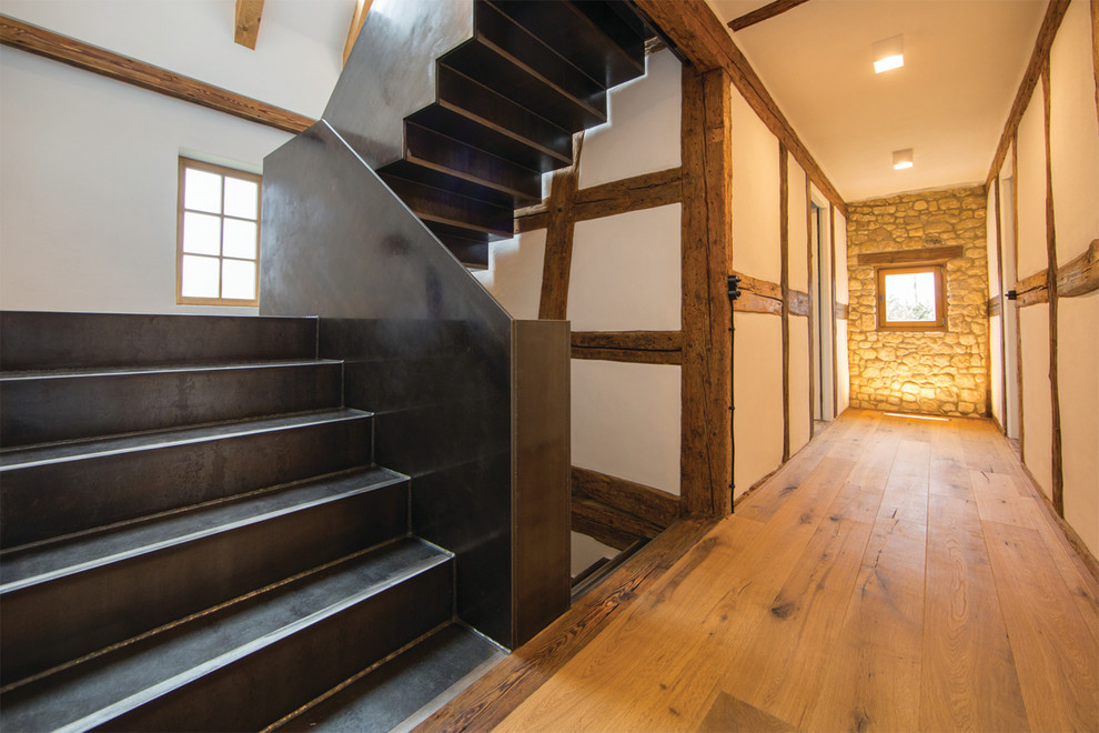 Inspiration for a rustic metal curved staircase remodel in Frankfurt with metal risers