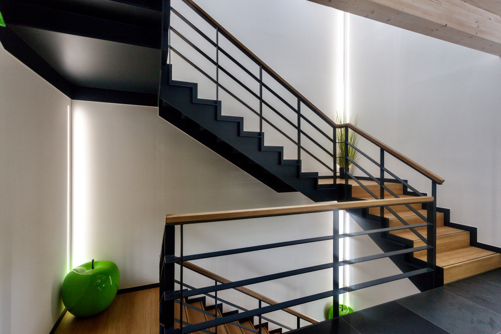 Foto de escalera en U moderna de tamaño medio con escalones de madera, contrahuellas de madera y barandilla de metal