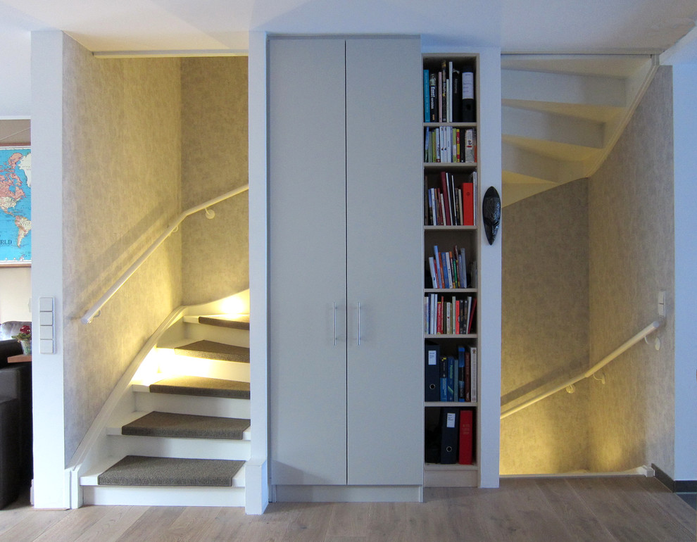 Exemple d'un escalier tendance en U de taille moyenne avec des marches en moquette, des contremarches en bois et un garde-corps en bois.