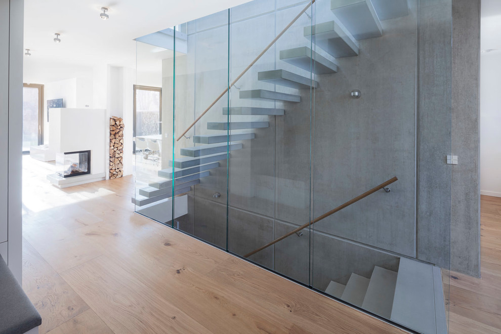 Inspiration for a medium sized contemporary concrete straight mixed railing staircase in Hamburg with open risers.
