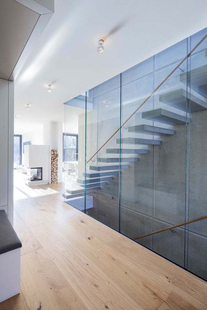 Свежая идея для дизайна: прямая лестница среднего размера в современном стиле с бетонными ступенями и стеклянными перилами без подступенок - отличное фото интерьера