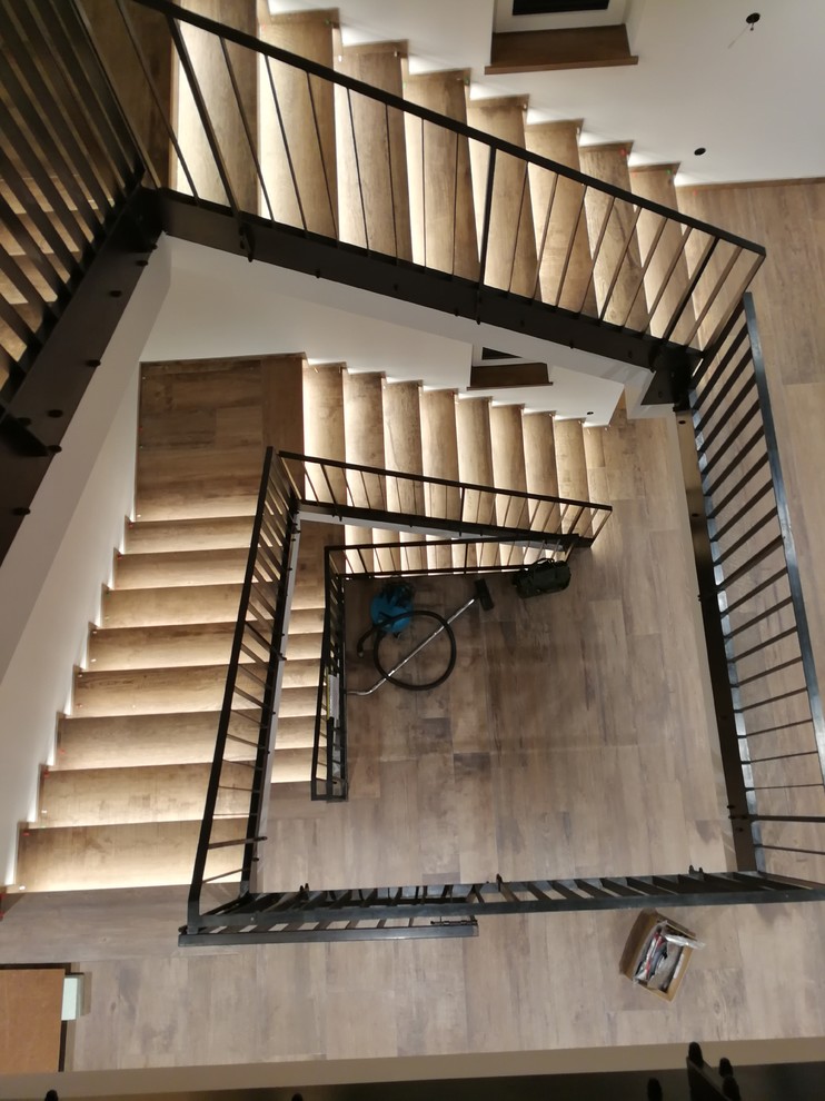 Gewendelte, Große Nordische Treppe mit gefliesten Treppenstufen, Metall-Setzstufen und Stahlgeländer in München