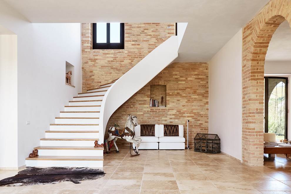 Diseño de escalera curva mediterránea grande con escalones de madera y contrahuellas de madera pintada