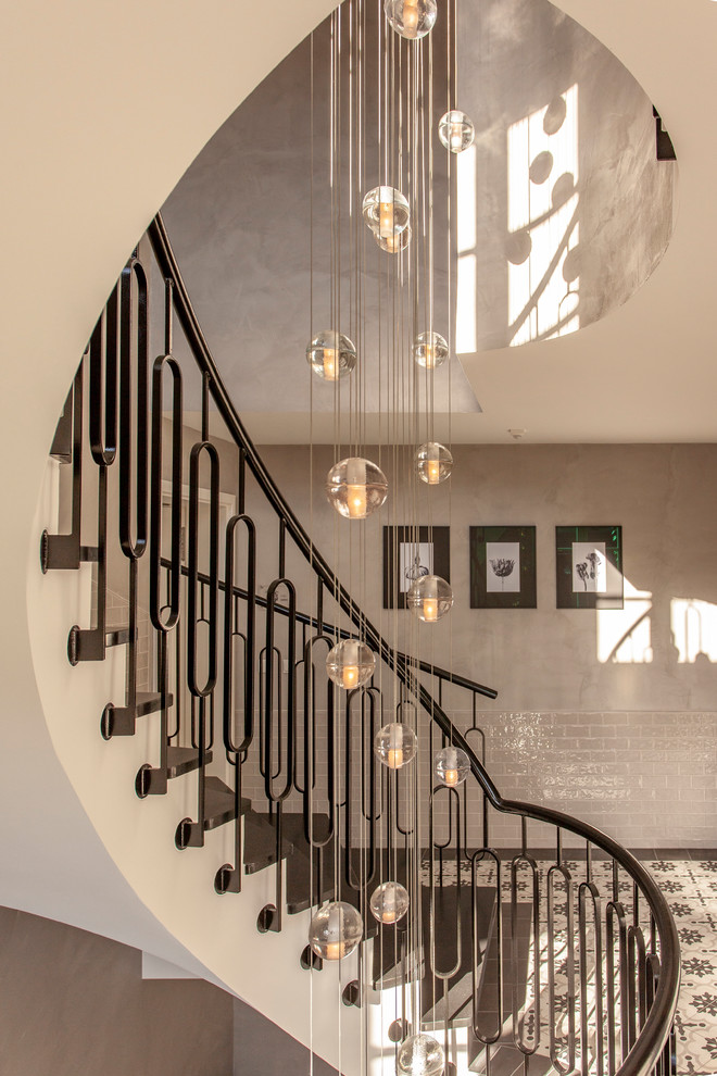 Стильный дизайн: большая винтовая лестница в классическом стиле с ступенями из сланца, подступенками из сланца и металлическими перилами - последний тренд