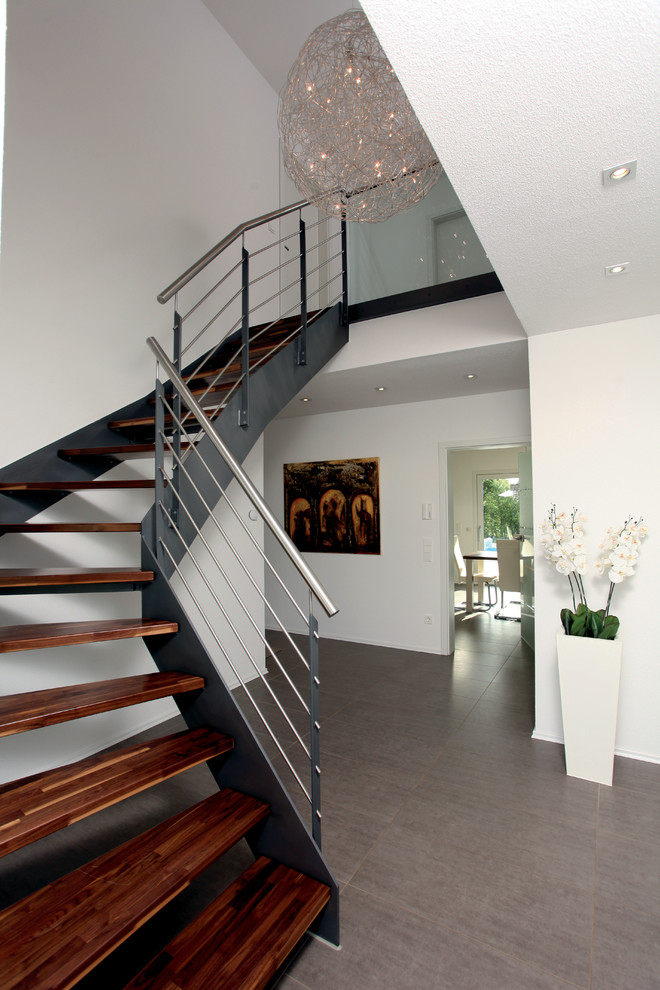 Стильный дизайн: угловая лестница в современном стиле с деревянными ступенями и металлическими перилами - последний тренд