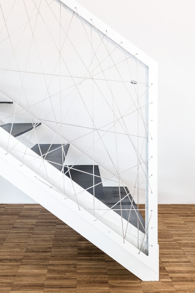 Ejemplo de escalera recta minimalista con escalones de metal y barandilla de cable