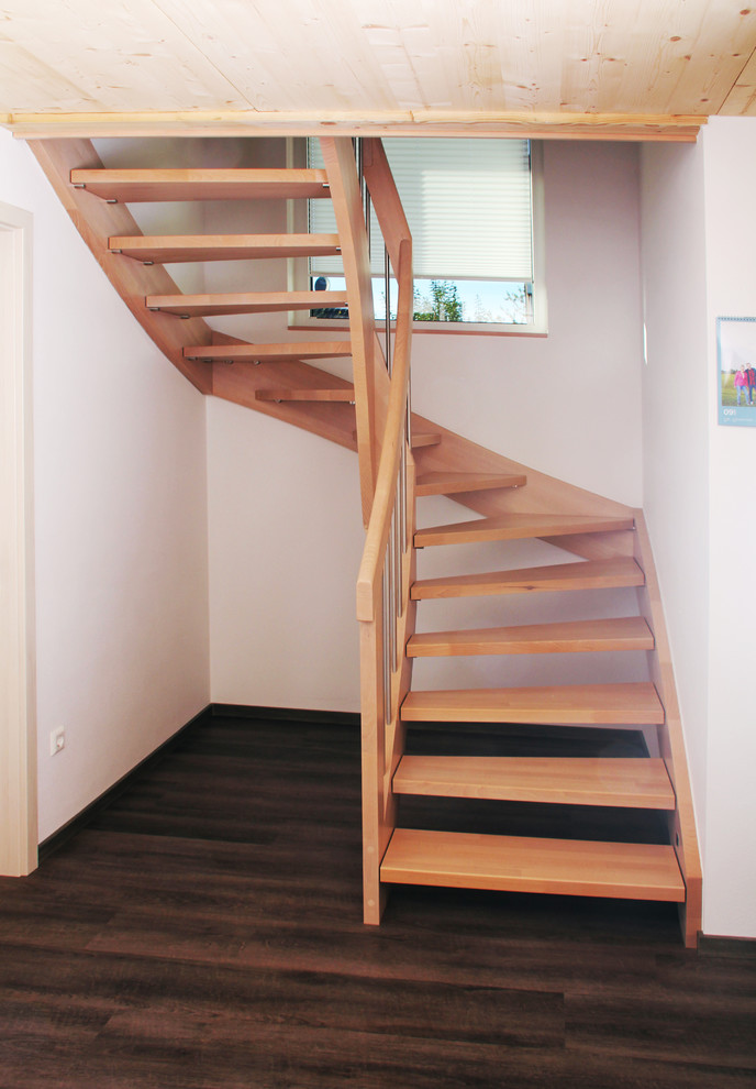 Exemple d'un escalier courbe chic de taille moyenne avec des marches en bois et un garde-corps en bois.