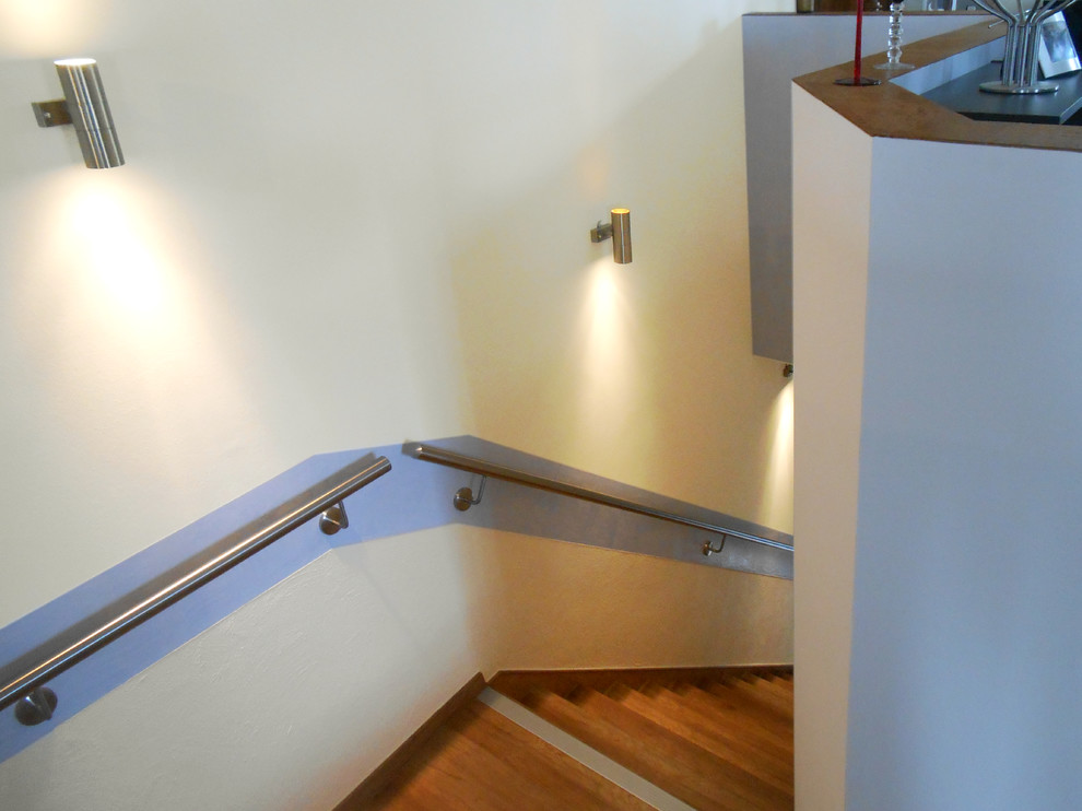 На фото: угловая бетонная лестница среднего размера в средиземноморском стиле с деревянными ступенями и металлическими перилами