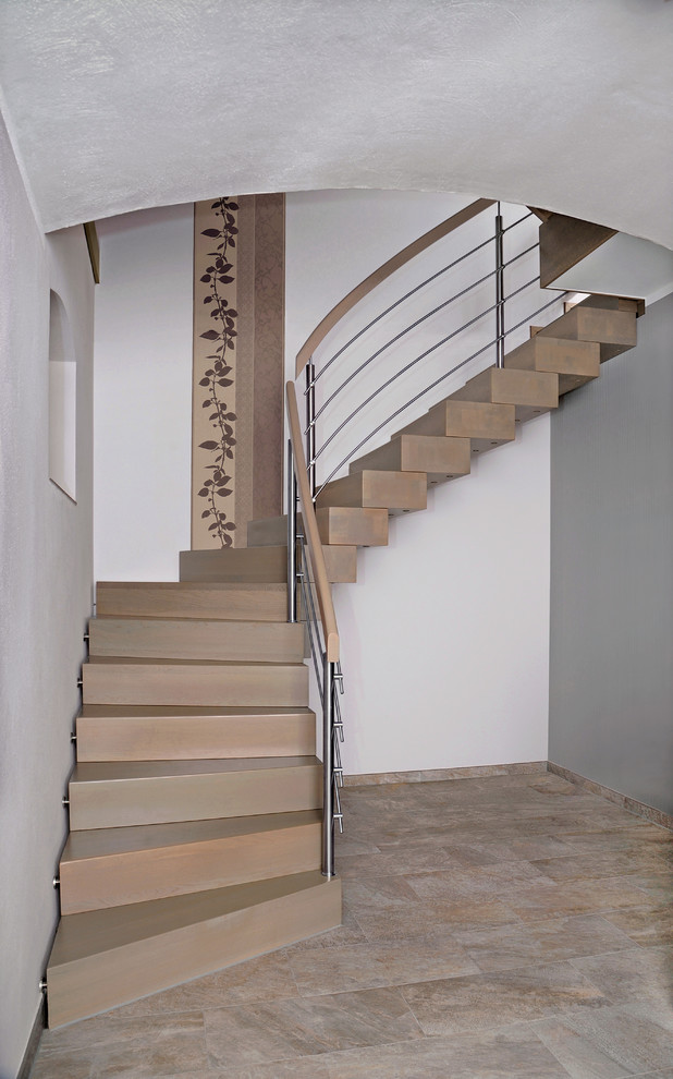 Стильный дизайн: изогнутая металлическая лестница среднего размера в современном стиле с металлическими ступенями и перилами из смешанных материалов - последний тренд