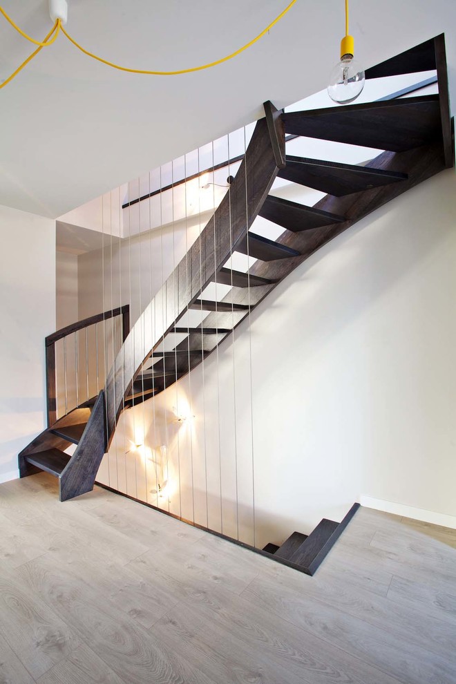 Foto de escalera curva tradicional grande con escalones de madera y contrahuellas de metal