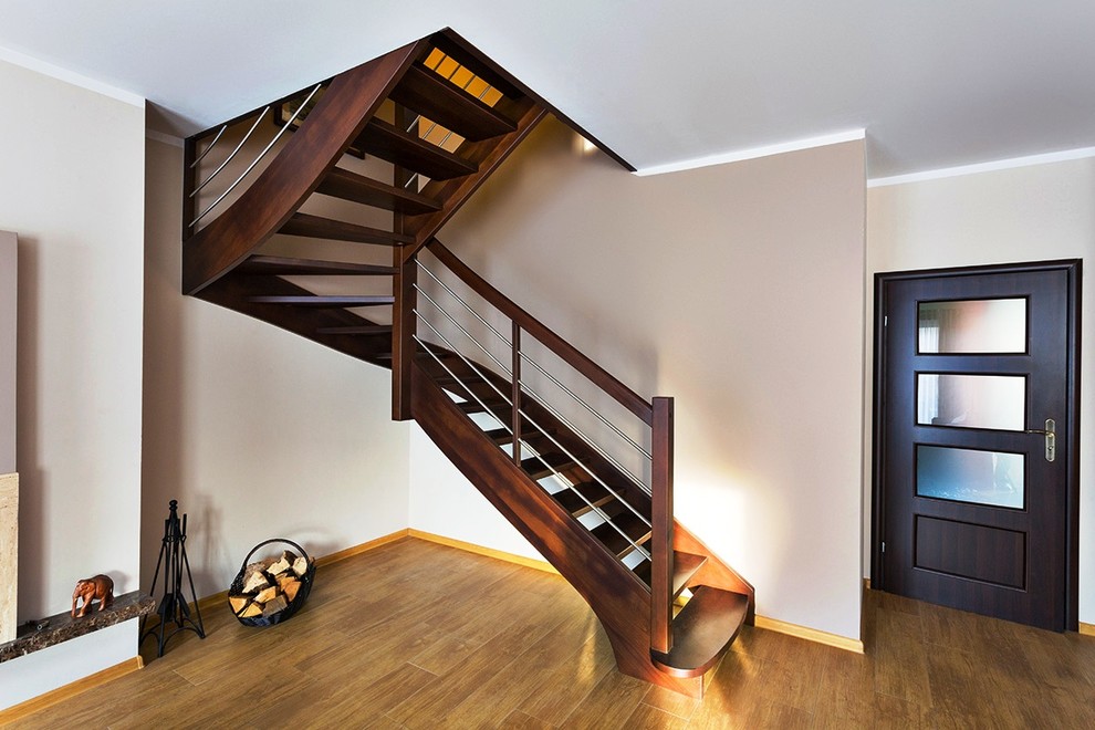 Exempel på en mycket stor klassisk svängd trappa i trä, med öppna sättsteg
