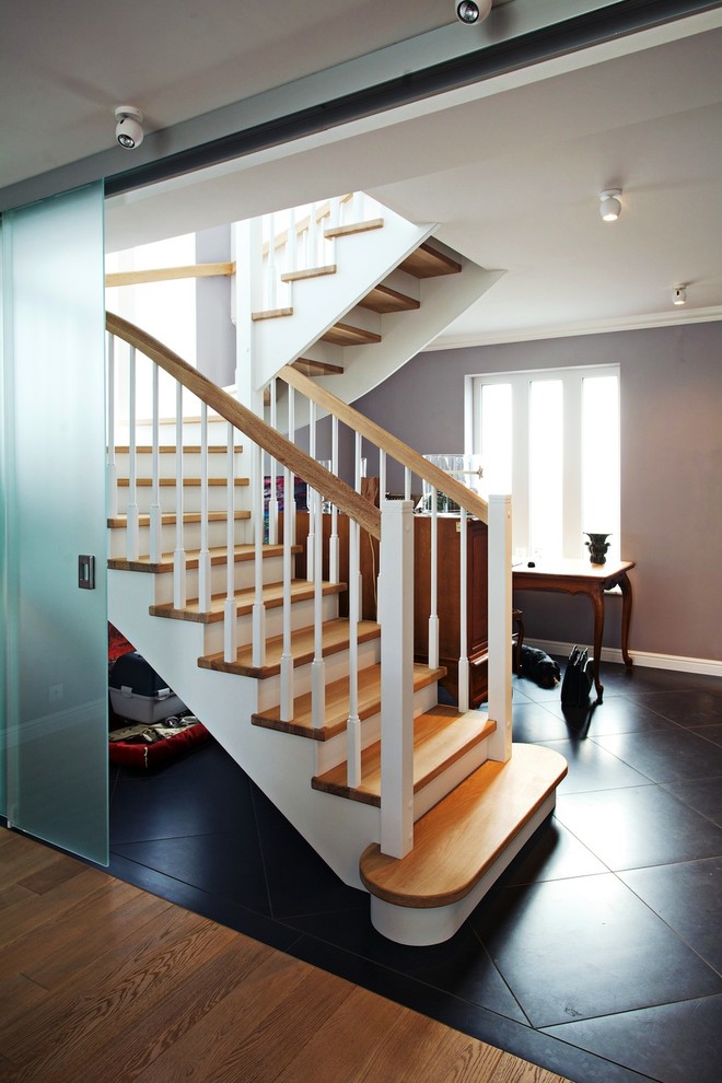 Cette image montre un grand escalier courbe traditionnel avec des marches en bois et des contremarches en bois.