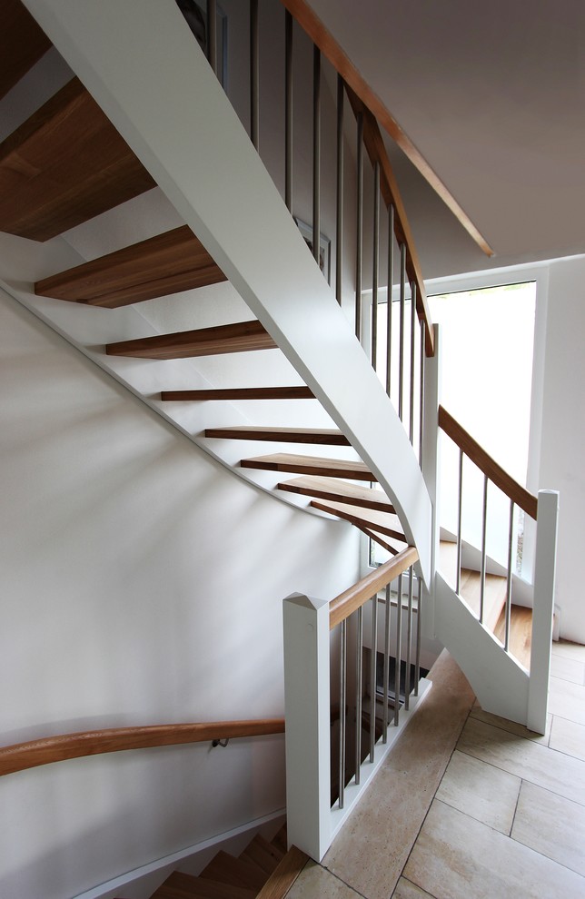 Cette photo montre un très grand escalier sans contremarche courbe chic avec des marches en bois.