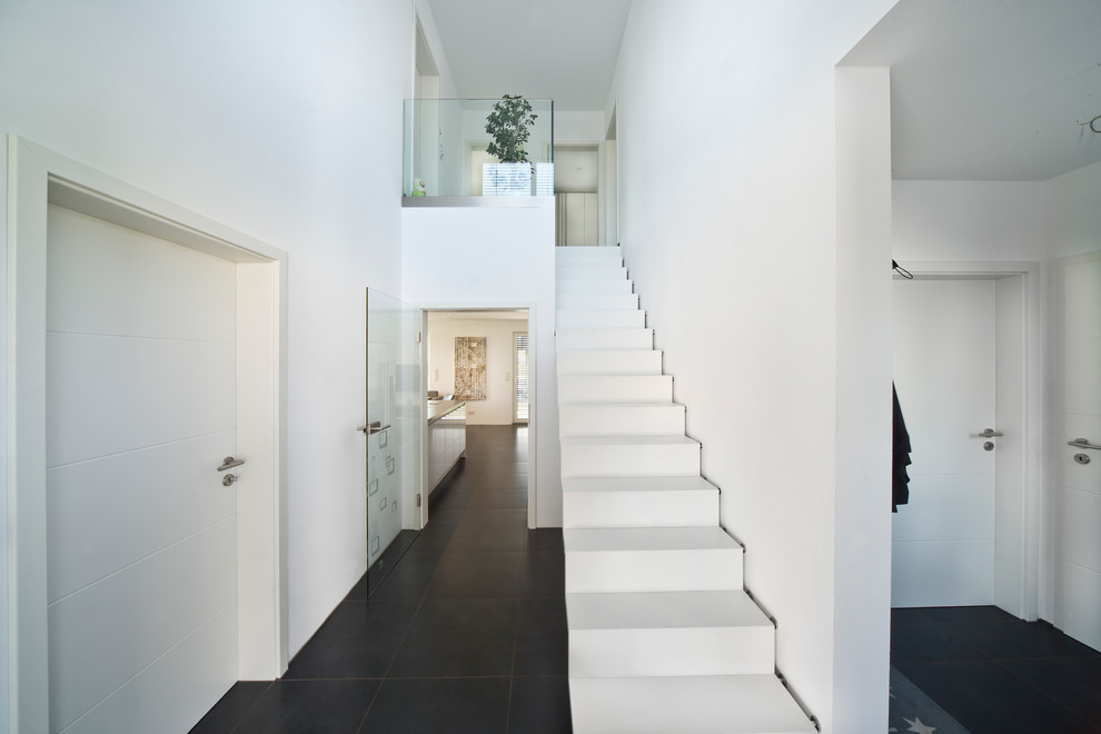 Foto de escalera recta moderna de tamaño medio con barandilla de vidrio