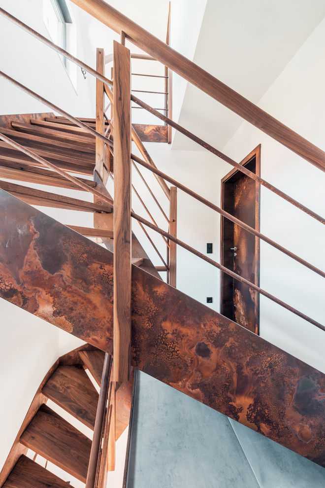 Exempel på en mellanstor industriell svängd trappa i trä, med räcke i metall