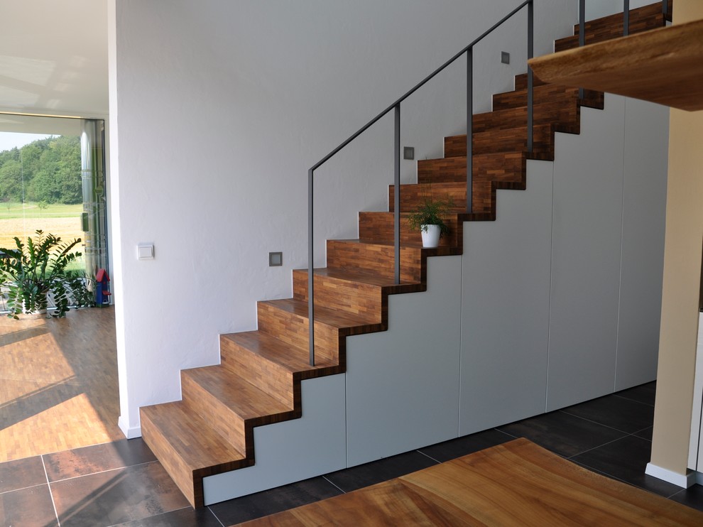 Réalisation d'un escalier droit design de taille moyenne avec des marches en bois, des contremarches en bois et rangements.