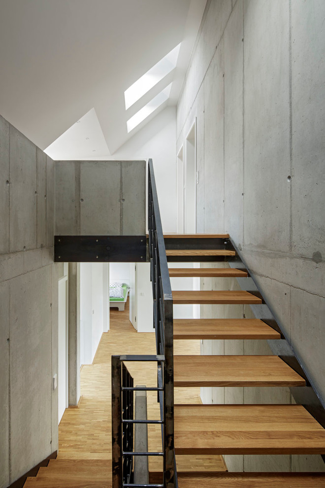 Design ideas for a medium sized industrial wood u-shaped staircase in Berlin with open risers.
