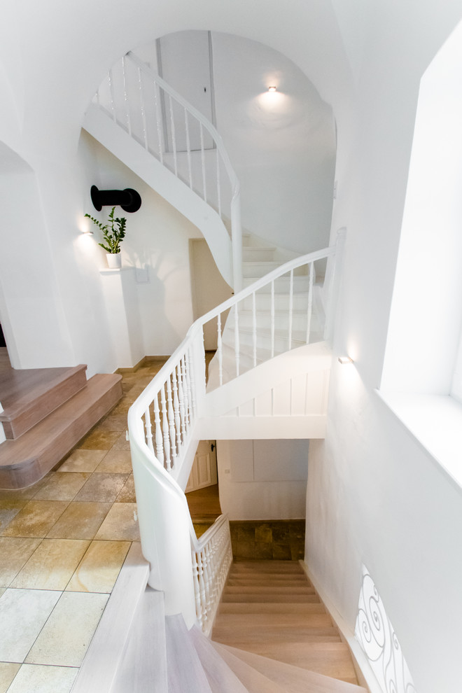 Example of a large transitional wooden curved staircase design in Other with wooden risers