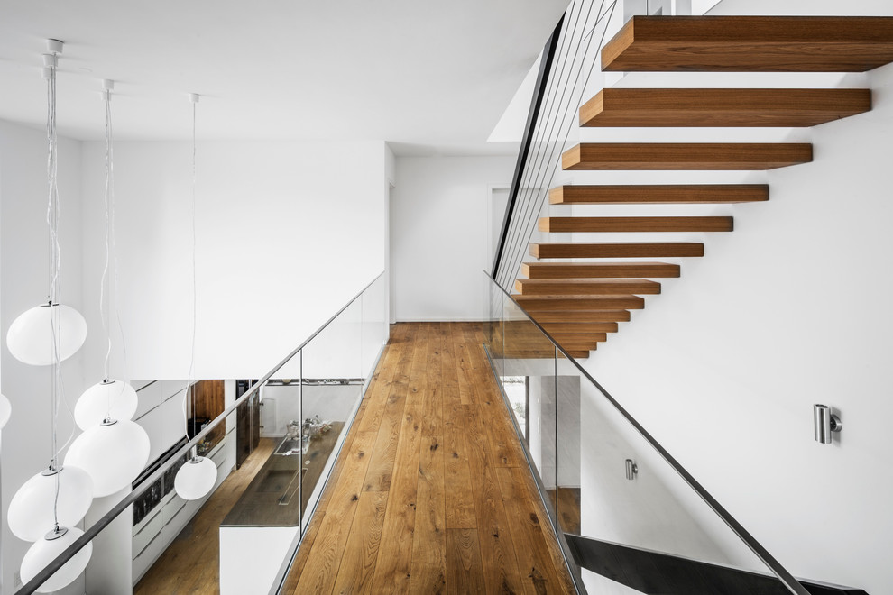Idéer för att renovera en stor funkis flytande trappa i trä, med öppna sättsteg