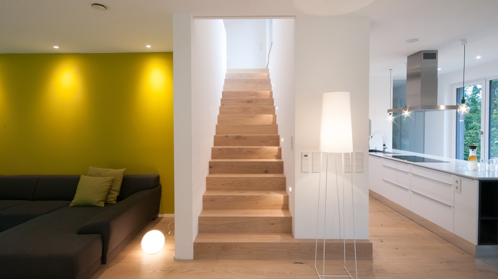 Idées déco pour un escalier droit contemporain de taille moyenne avec des marches en bois, des contremarches en bois et éclairage.