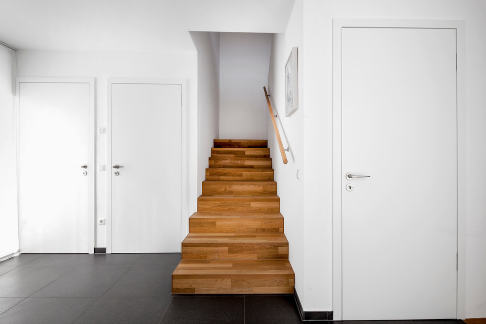 Inspiration for a small contemporary wood straight staircase in Cologne with wood risers.