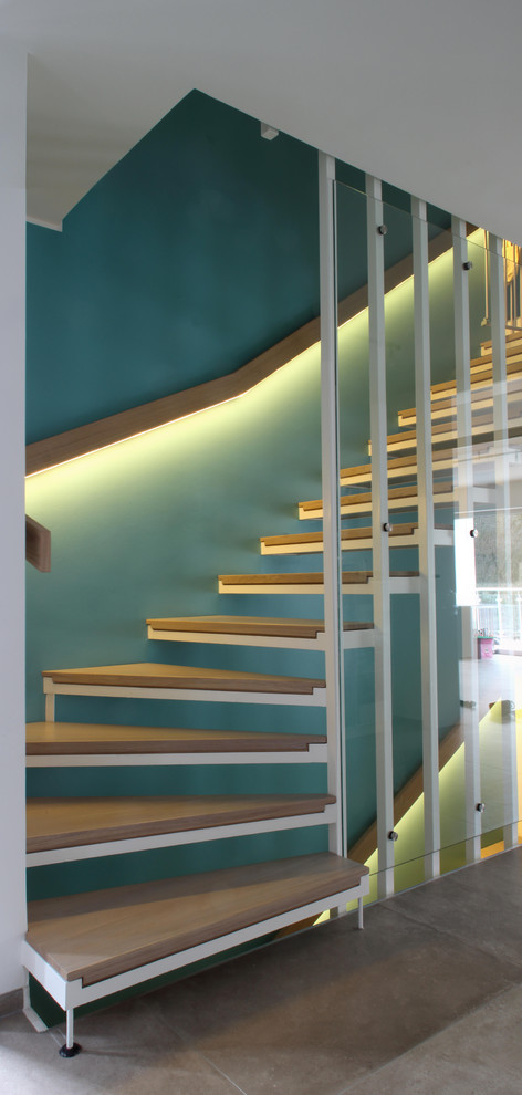 Пример оригинального дизайна: изогнутая лестница среднего размера в современном стиле с крашенными деревянными ступенями и перилами из смешанных материалов без подступенок
